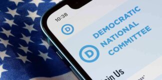 Smartphone screen showing Democratic National Committee website above flag.