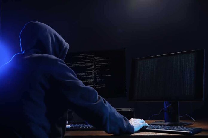 1708895812 featured image Hooded figure working on computers in dark room