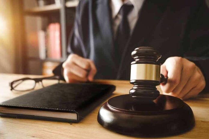 1035925210 featured image Person in suit with gavel at desk