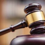 Wooden gavel hitting block in courtroom setting