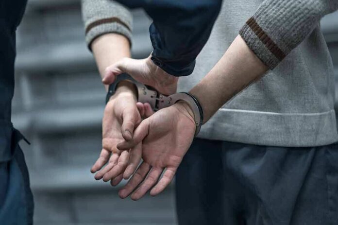 1904367880 featured image Person in handcuffs, hands behind their back.