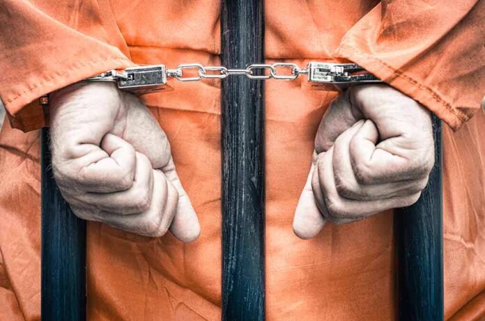 217094626 featured image Hands cuffed in front of prison bars