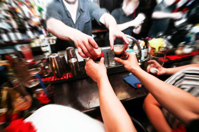362651360 featured image Bartender handing shots to customers at bar