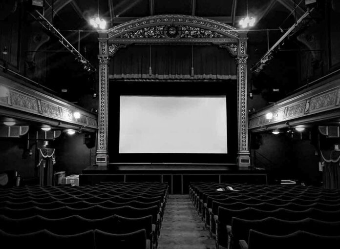 1308647422 featured image Empty theater with ornate decor and projection screen.