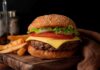 Cheeseburger with fries on a wooden board.
