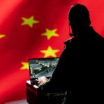 Person using laptop with Chinese flag background