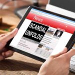 Person reading news headline Scandal Unfolds on table