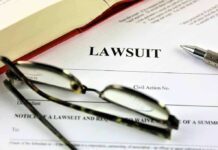 Lawsuit paperwork with glassespenand an open book