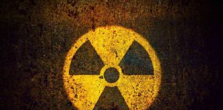 Yellow radiation warning symbol on rusty metal surface