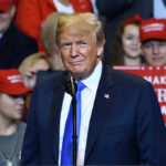 Person at a rally with Make America Great Again signs