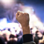 Raised fist in a crowd at night