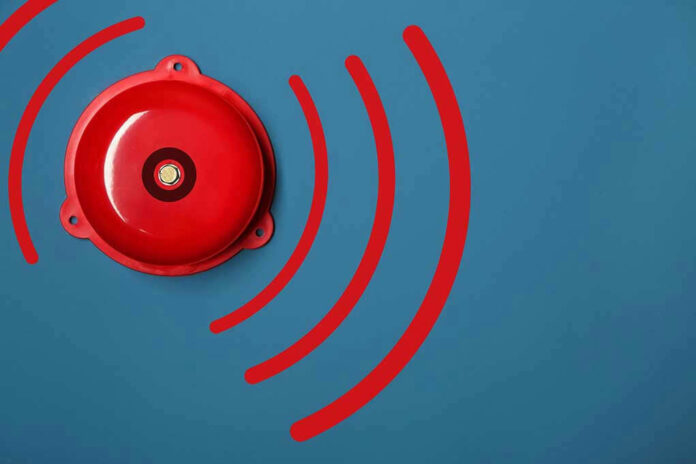 1311134939 Red alarm bell on a blue background