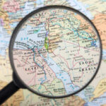 Magnifying glass over Middle East map highlighting Israel and Egypt