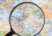 Magnifying glass over Middle East map highlighting Israel and Egypt