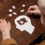 Elderly person completing head shaped jigsaw puzzle