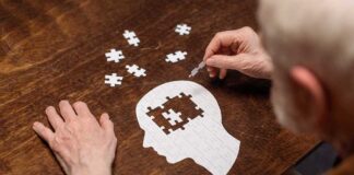 Elderly person completing head shaped jigsaw puzzle