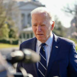 Elderly man in suit speaking outdoors