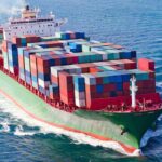A large cargo ship loaded with colorful containers sailing on the ocean