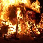 A large fire engulfing debris at night