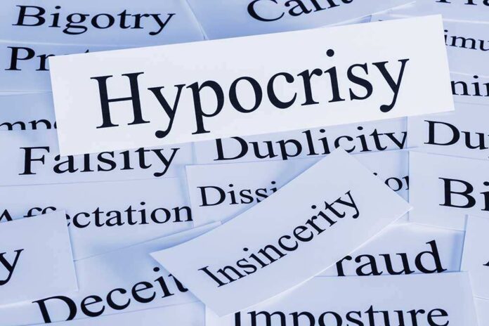 A collection of paper cards with various negative terms, prominently featuring the word Hypocrisy