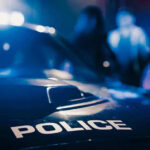 Police car with blurred figures in the background.