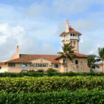 Developer’s OUTRAGEOUS $169M Flip Raises Questions Large pink mansion with tower, palm trees, and garden.