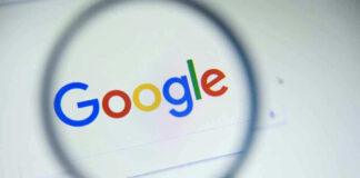 Google logo viewed through a magnifying glass.