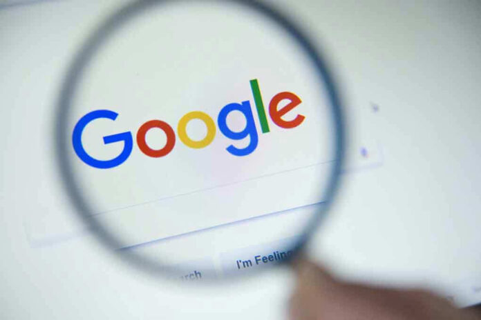 Google logo viewed through a magnifying glass.