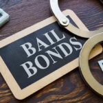 A bail bonds sign with handcuffs and stacks of cash