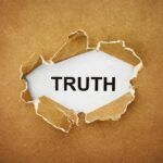 A piece of torn paper revealing the word TRUTH underneath