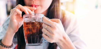 Person drinking soda from a glass mug