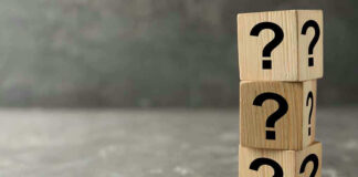 Three wooden blocks with question marks stacked.
