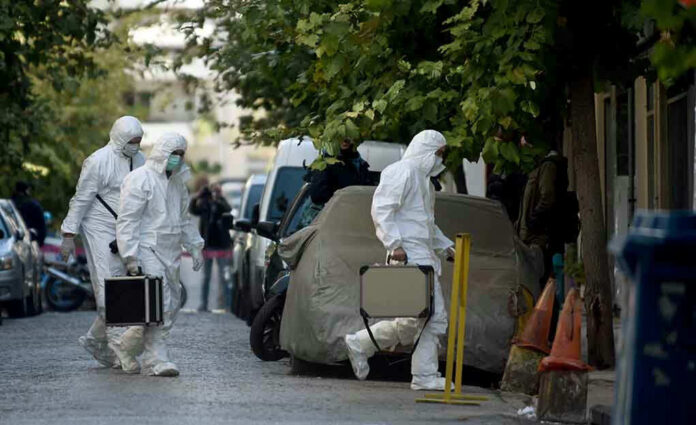 Investigators in hazmat suits carrying equipment cases.
