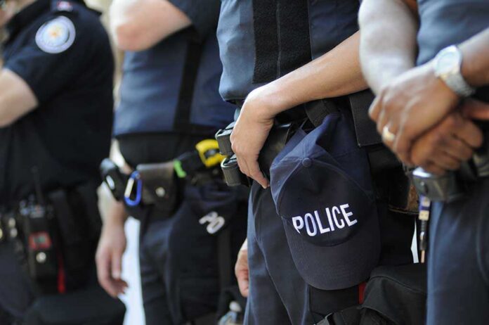 Group of police officers in uniform standing together with a police cap visible