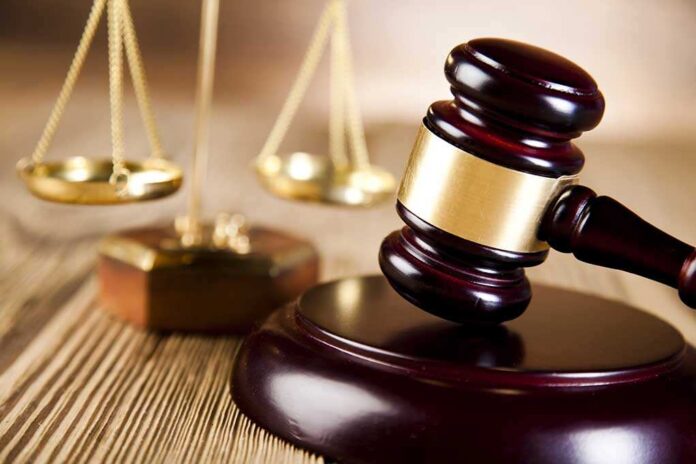 A wooden gavel and scales of justice on a table