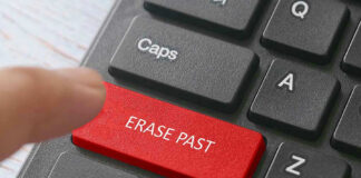 Finger pressing ERASE PAST key on keyboard.