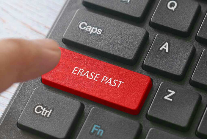 Finger pressing ERASE PAST key on keyboard.