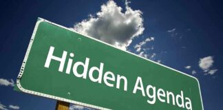 Road sign displaying the phrase Hidden Agenda against a blue sky