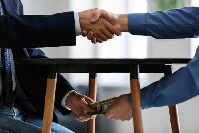 Handshake and exchange of money under the table.