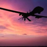 Mysterious Drones Threaten Nuclear Secrets Silhouette of a drone against a colorful sunset.
