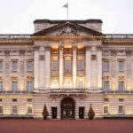 Duke ARRESTED – Strangulation Charges Filed Front view of Buckingham Palace with illuminated facade and British flag