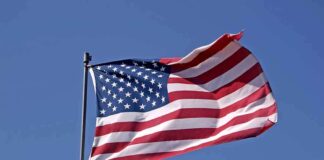 Waving American flag against a clear blue sky