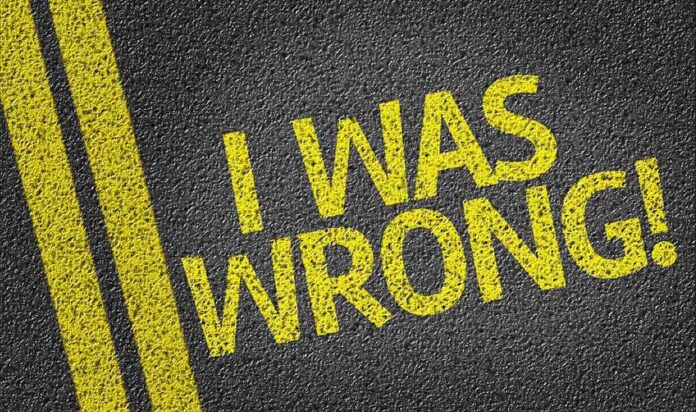 Bold yellow text on a dark asphalt surface stating I WAS WRONG!