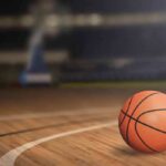 A basketball resting on a wooden court
