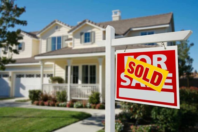 A house with a Sold sign in the front yard
