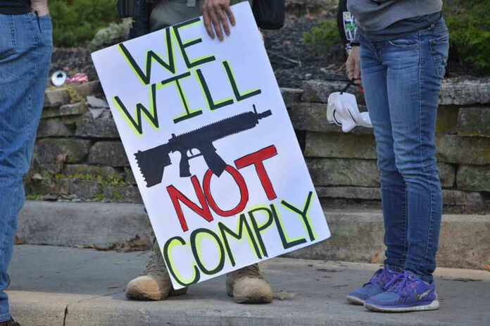 Protest sign reads: We Will Not Comply.