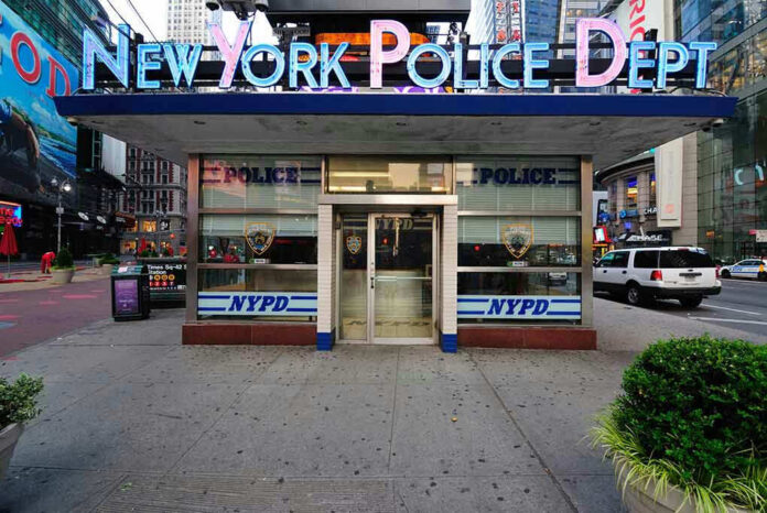 NYPD precinct building with signs on a city street