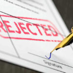 WHO Rejected: America WALKS After Lab COVER-UP Rejected stamp on a document with pen.