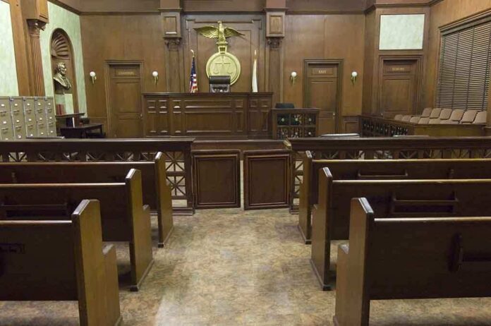 Interior view of an empty courtroom with wooden benches and a judges bench