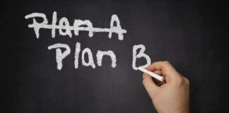 A hand writing Plan B on a chalkboard with Plan A crossed out